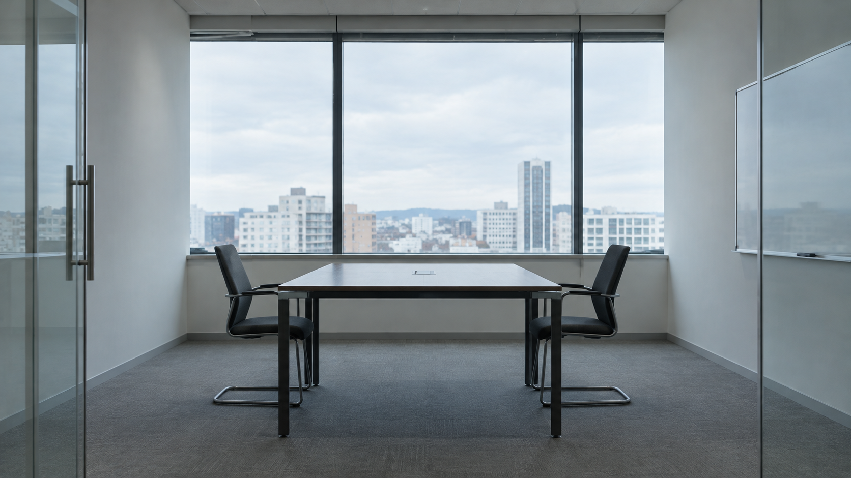 Two chairs facing each other across an empty meeting table